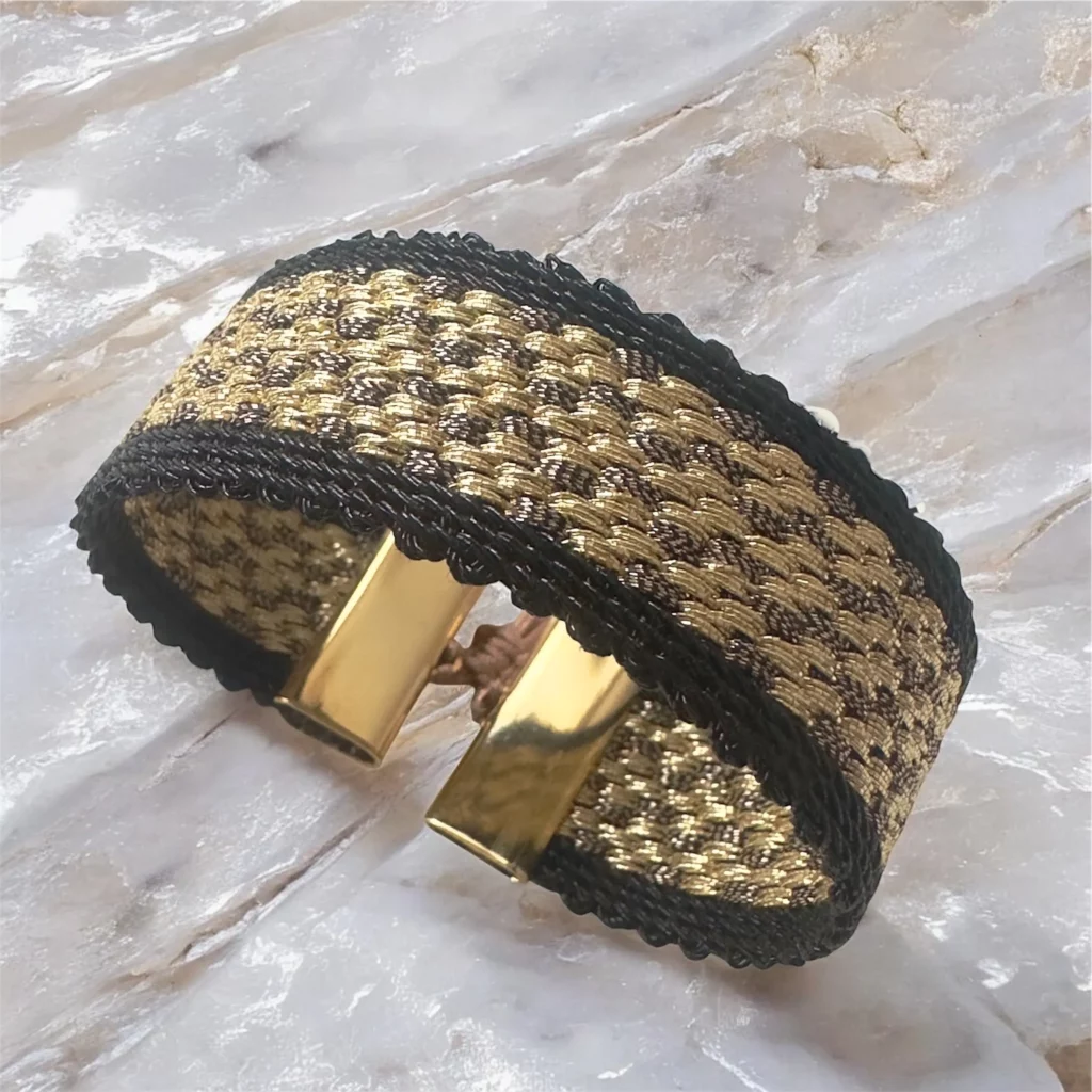 Manchette tissée SARAH de 20 mm en fils dorés et bronze, bordure noire, bijou artisanal ajustable Hanfaz.