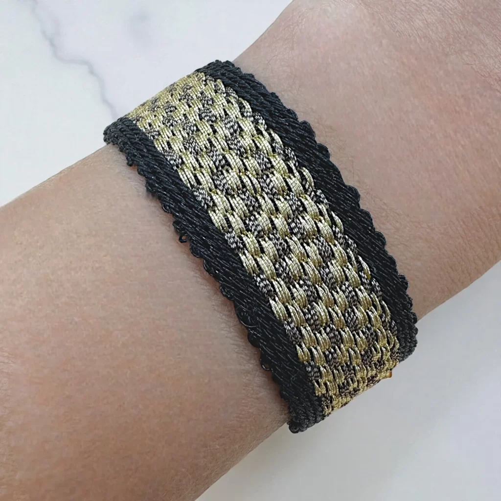 Manchette tissée SARAH de 20 mm en fils dorés et bronze, bordure noire, bijou artisanal ajustable Hanfaz.